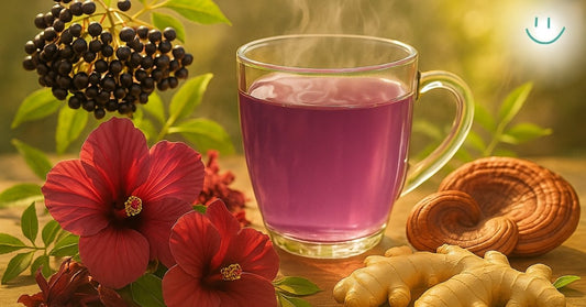 Glass of purple tea with elderberries, hibiscus flowers, ginger root, and reishi mushrooms on a wooden surface.